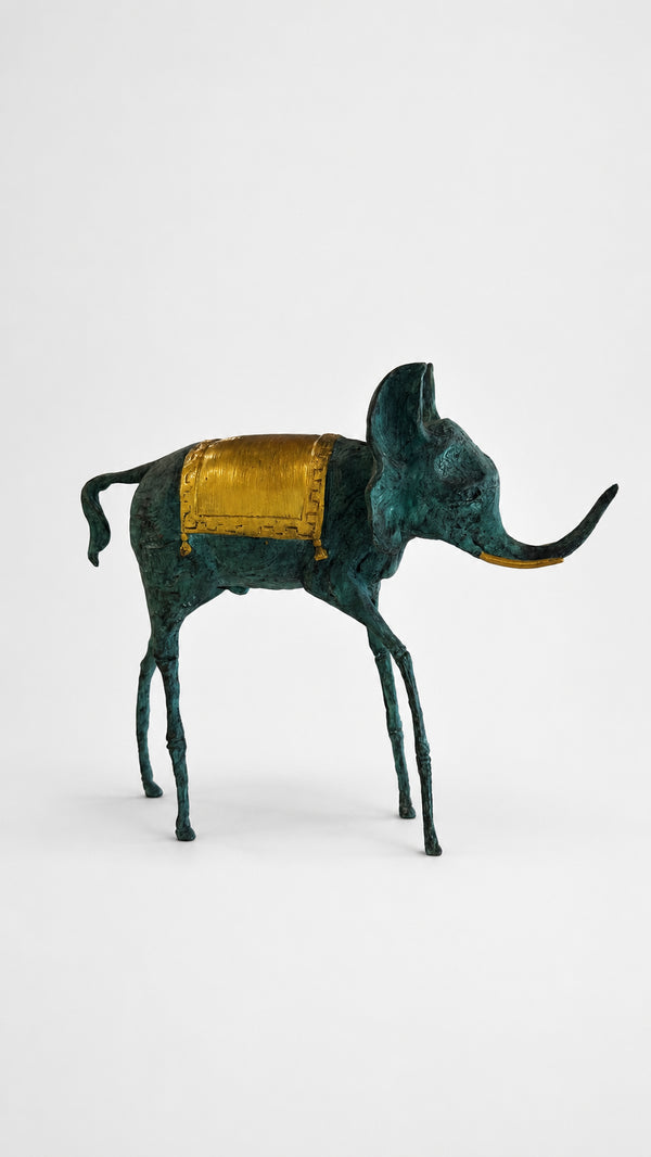 green bronze elephant sculpture with a gold saddle on a white background. Side view.